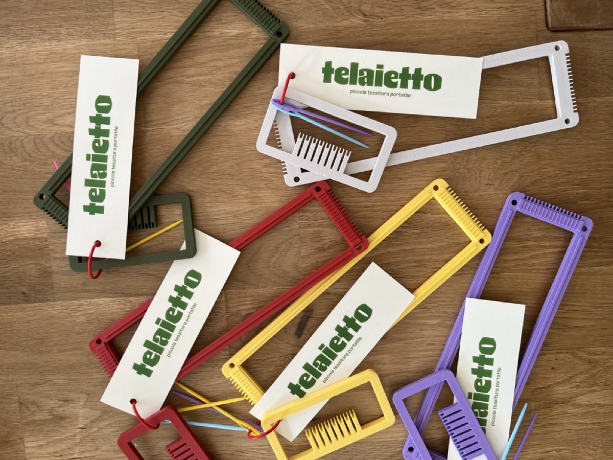 Telaietti colorati in viola, giallo, rosso e verde con i loro cartellini, appoggiati su un tavolo di legno